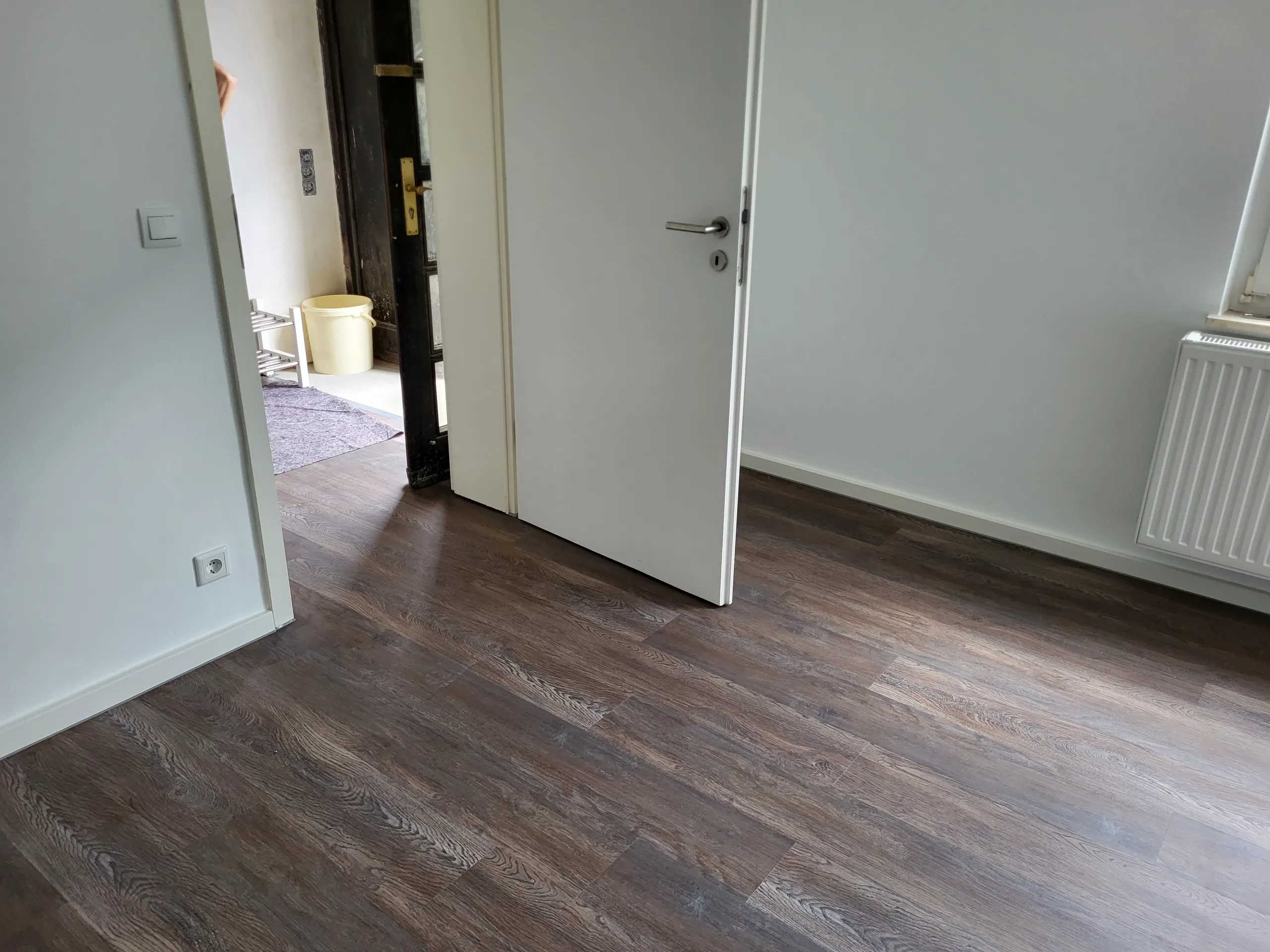 Raum mit neu verlegtem Laminatboden und offener Innentür, Laminat verlegen
