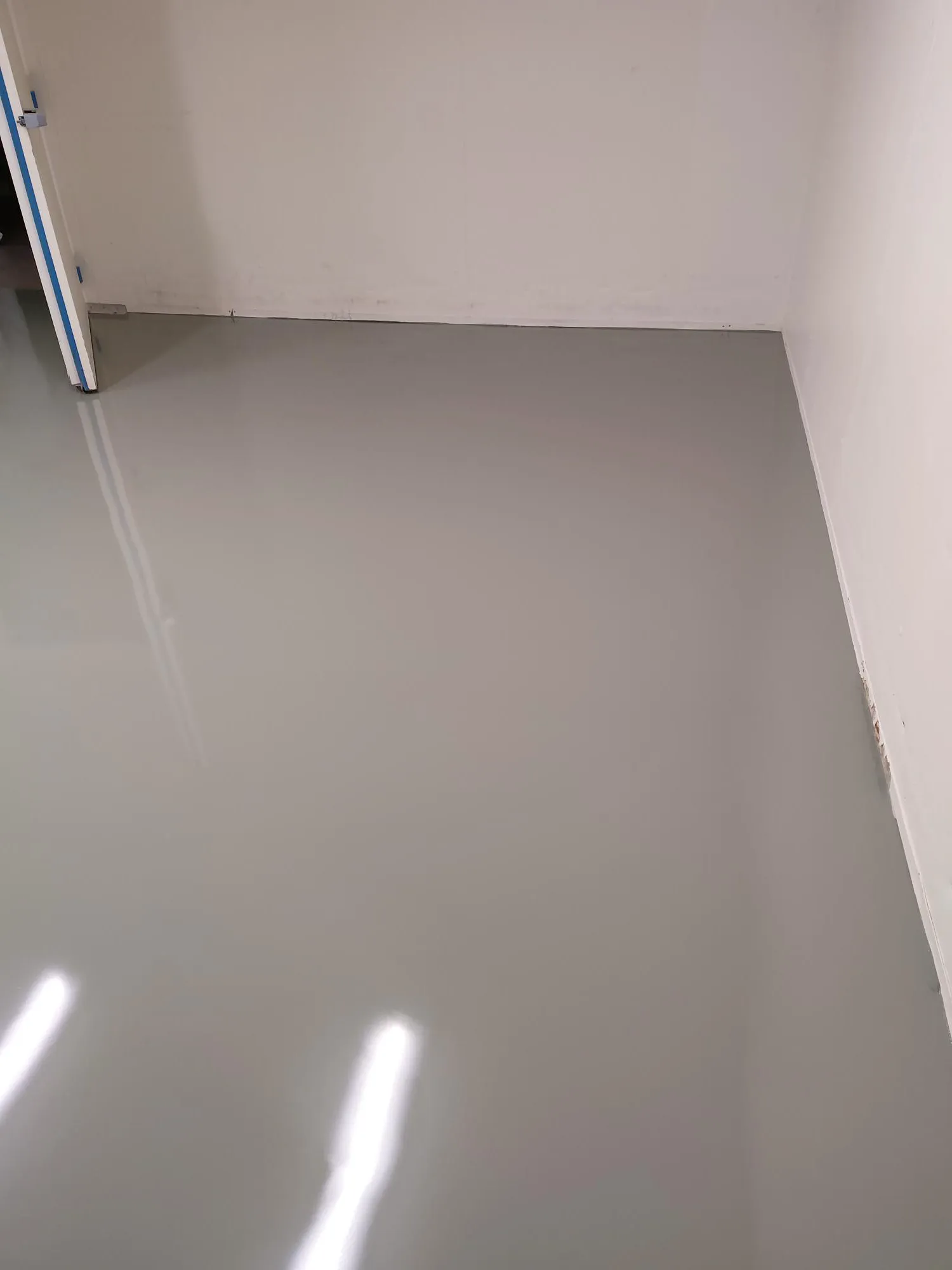 Leerraum mit glattem, glänzend grauen Boden aus Epoxidharz