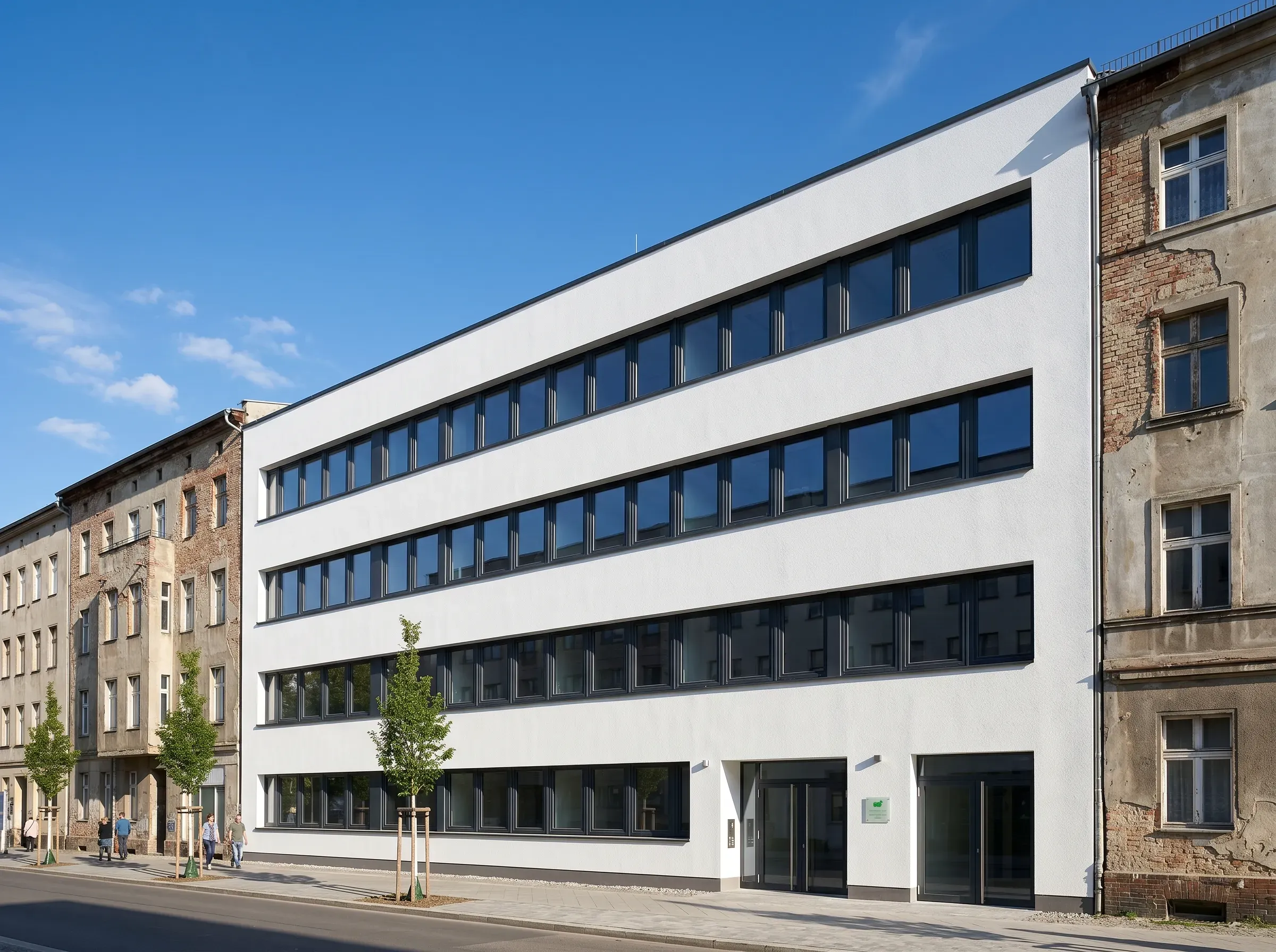 Renovierte weiße Fassade mit gleichmäßig angeordneten Fenstern an einem Wohngebäude und frisch angelegtem Gehweg – Fassadensanierung