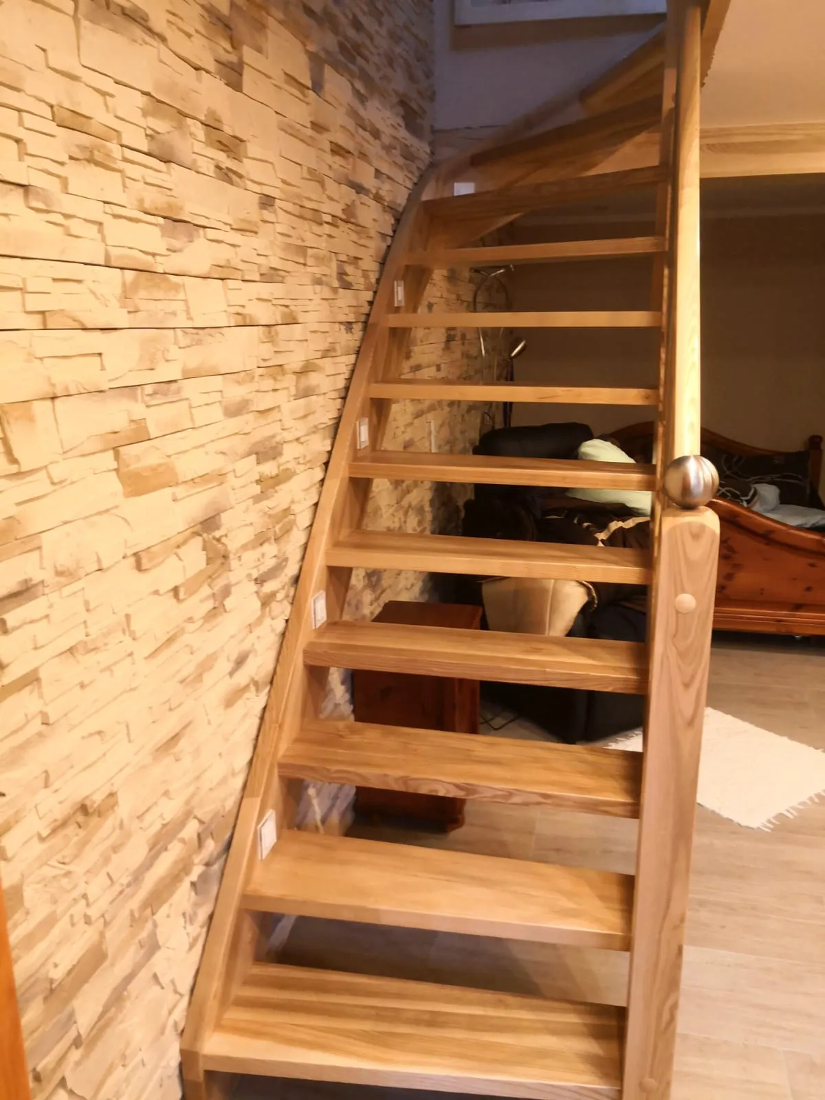 Freitragende Holztreppe mit offenem Stufenwerk und Holzgeländer im modernen Innenbereich