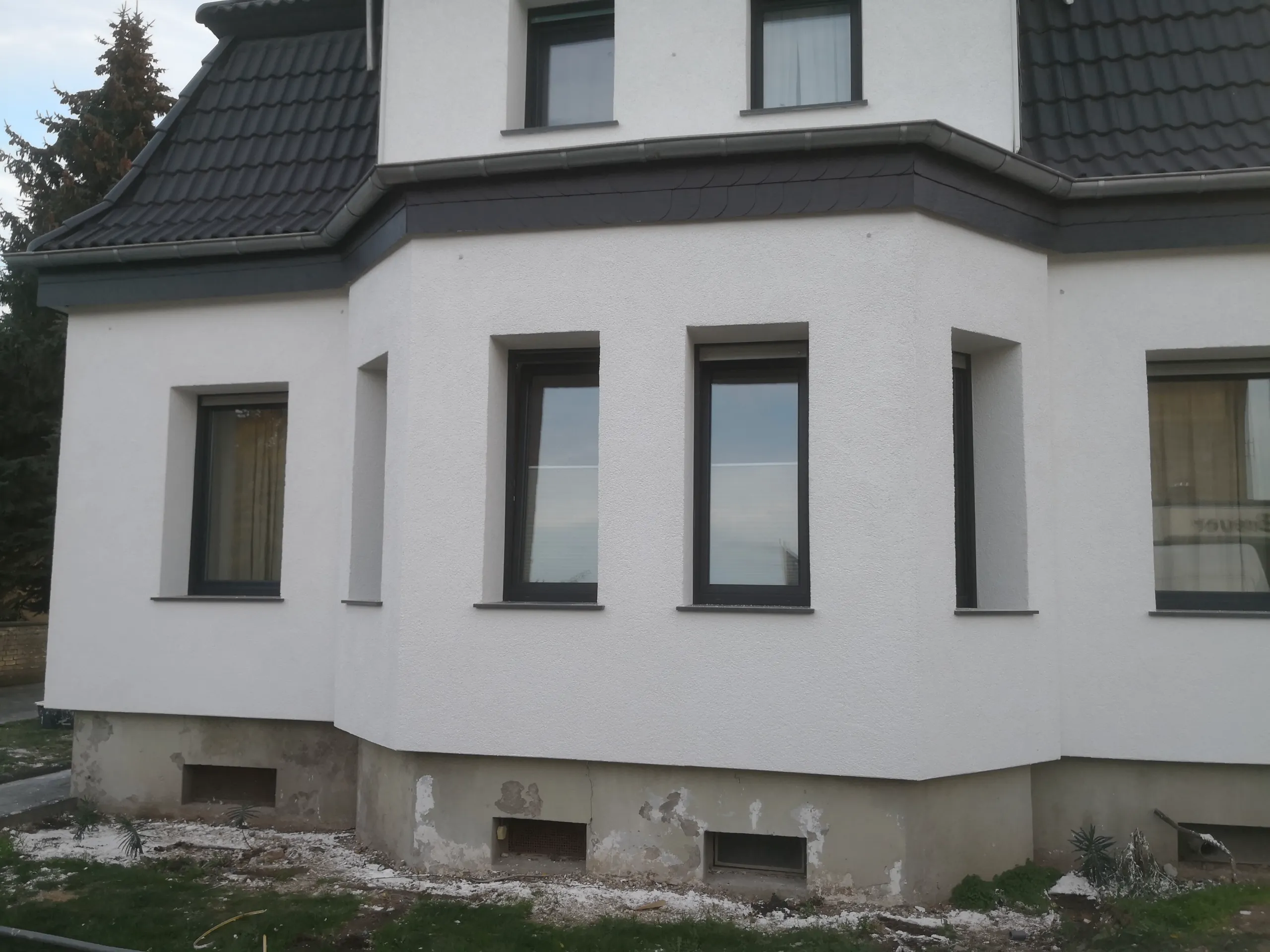 Fassadensanierung mit neuem Wärmedämmverbundsystem und modernen Fenstern an Wohnhaus