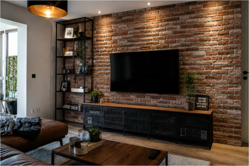 Modernes Wohnzimmer mit roter Klinkerriemchen-Wand, TV-Board, Regalen und Couch