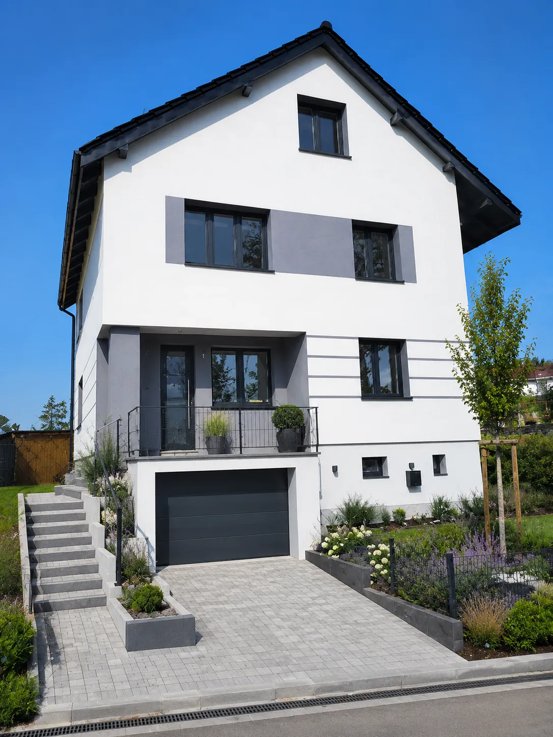 Moderner weißer Neubau mit gepflasterter Einfahrt und Seitentreppe, Pflasterarbeiten