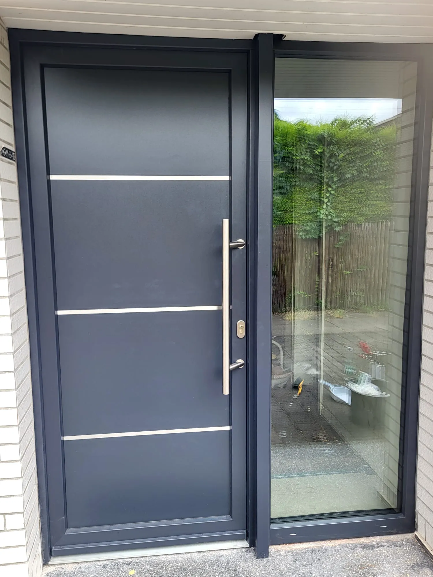 Moderne anthrazitfarbene Außentür mit Glas-Seitenteil und Edelstahlgriff