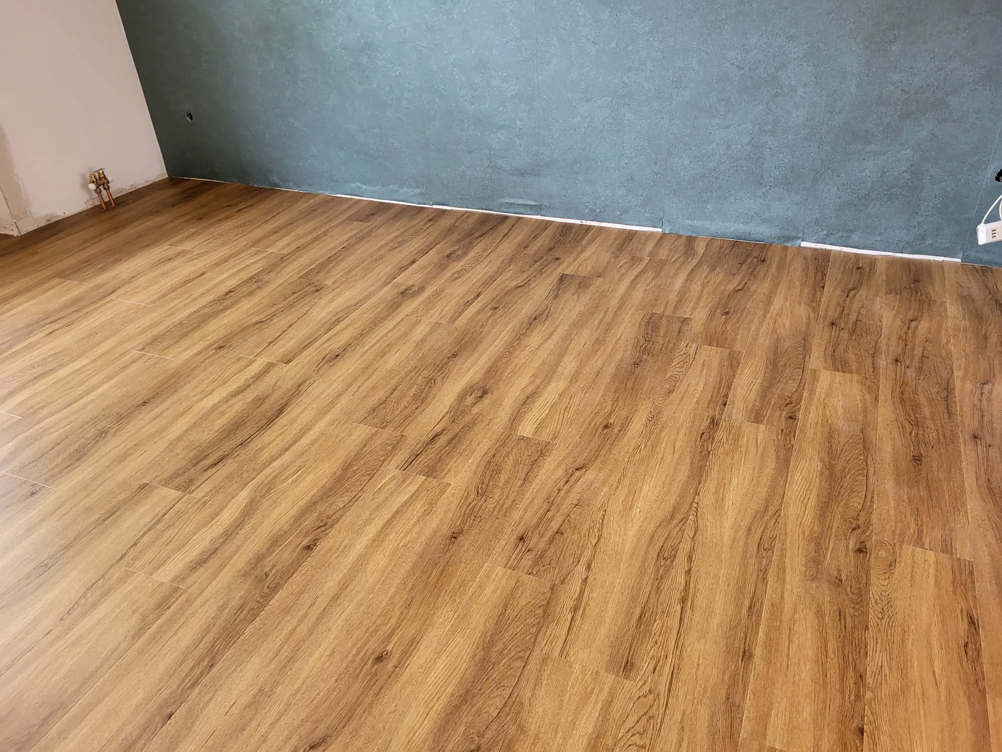 Neu verlegter Laminatboden in Eichenoptik in vorbereiteter Innenraum