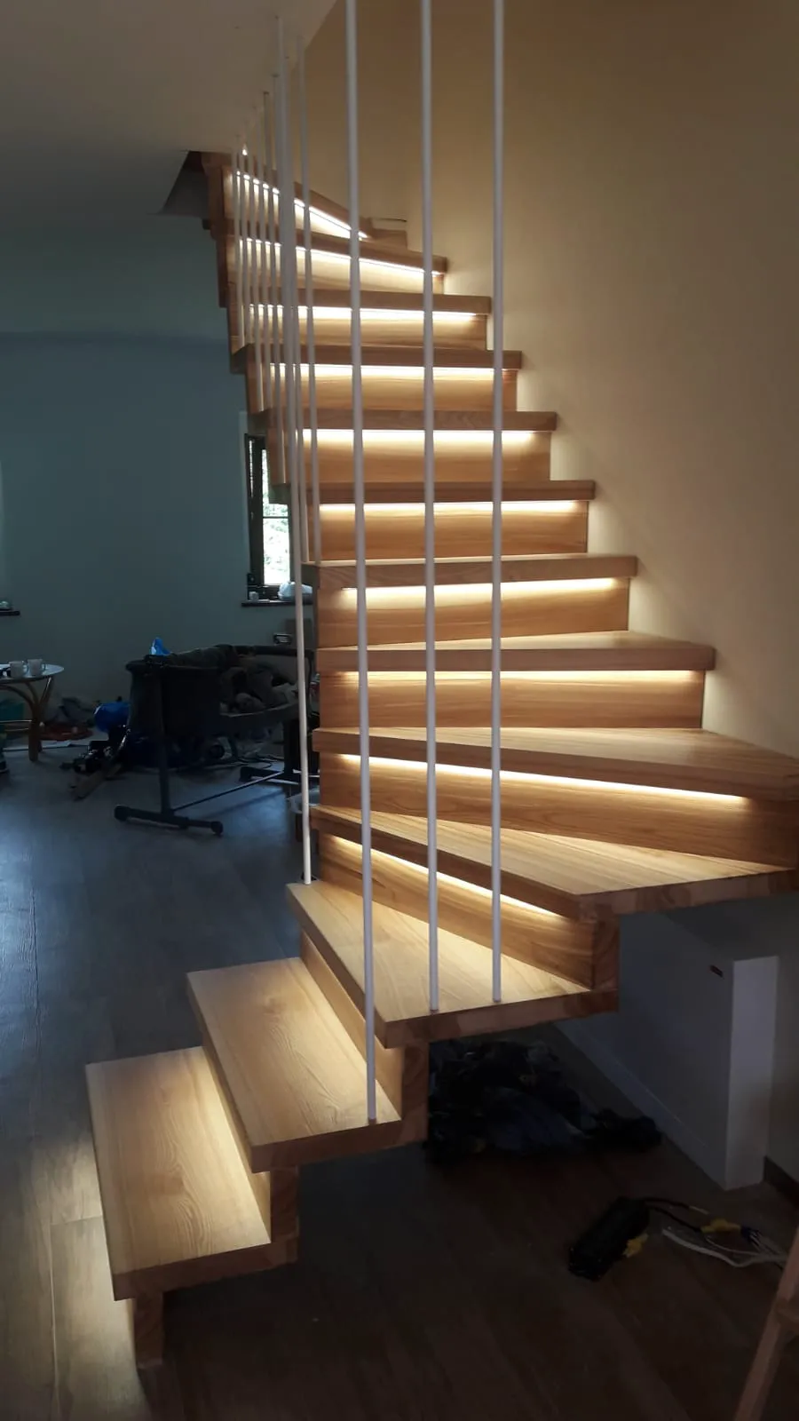 Moderne Holztreppe mit integrierter LED-Beleuchtung und weißen Geländerstäben