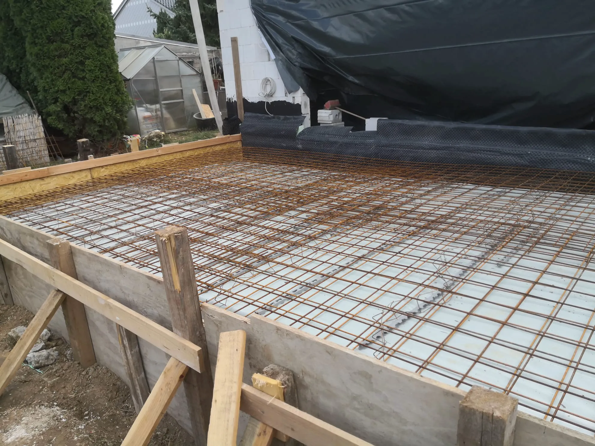Armierung für Betonfundament: Stahlgitter auf Bodenplatte mit Holzverschalung