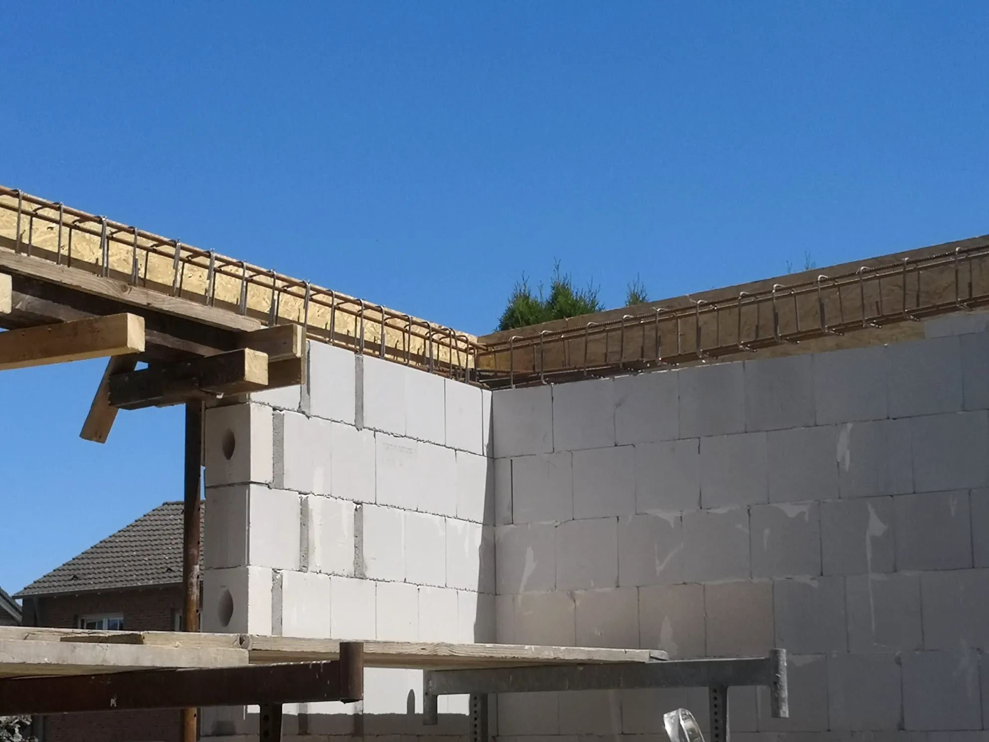 Unverputztes Porenbetonmauerwerk im Rohbau mit Stahlbewehrung – Maurerarbeiten auf Baustelle