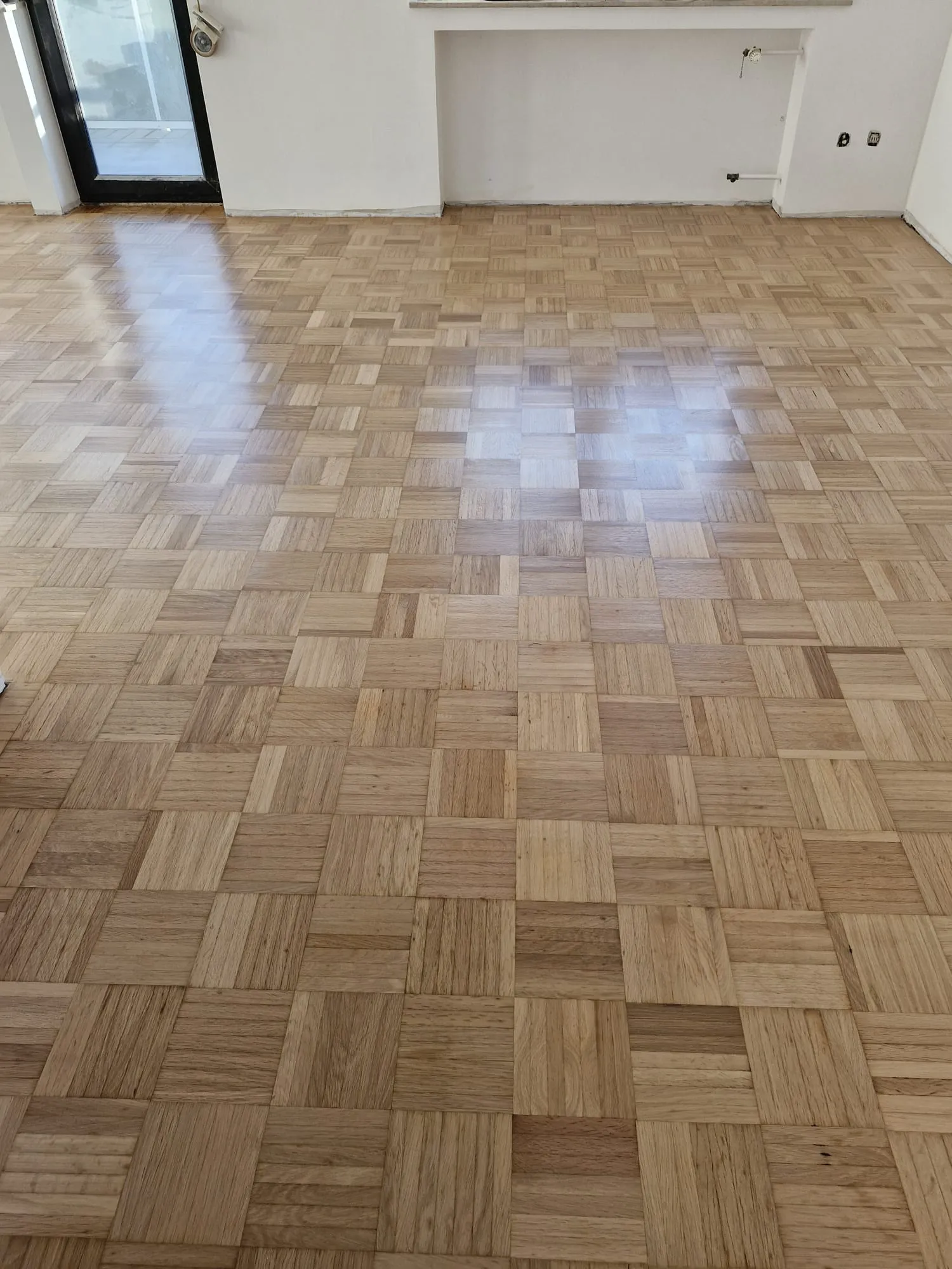 Leerer Raum mit frisch verlegtem Parkettboden im Schachbrettmuster Parkett verlegen