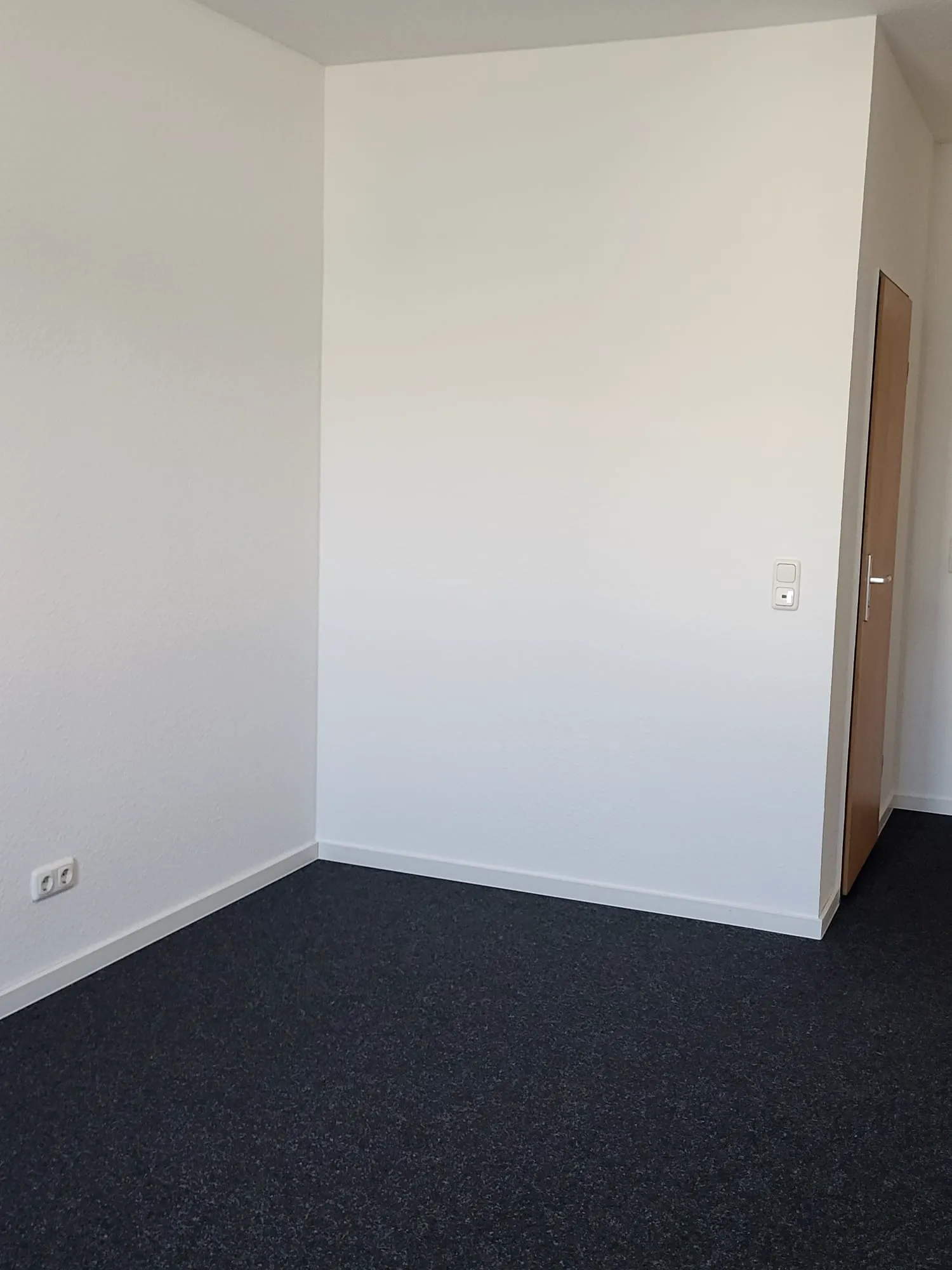 Leerer weißer Raum mit frisch verlegtem grauen Teppichboden und Türrahmen, Teppichboden verlegen