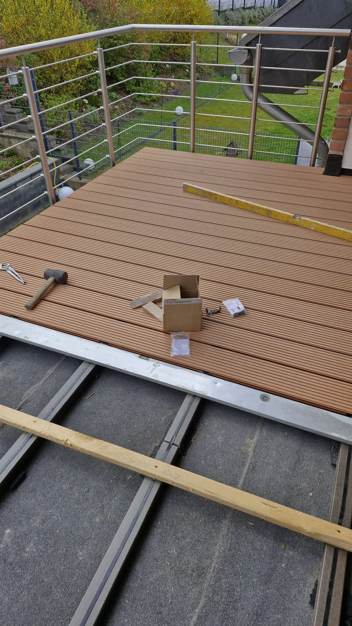 Terrassenbau mit WPC-Dielen auf Metall-Unterkonstruktion, Schrauben und Werkzeugen im Einsatz