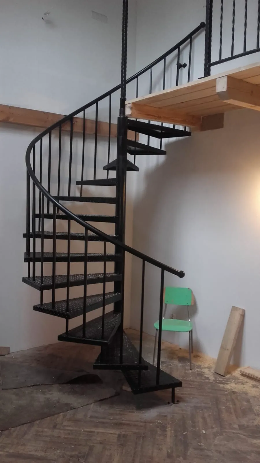 Schwarze Stahltreppe in Spiralform im Innenbereich auf Baustelle im Rohbau