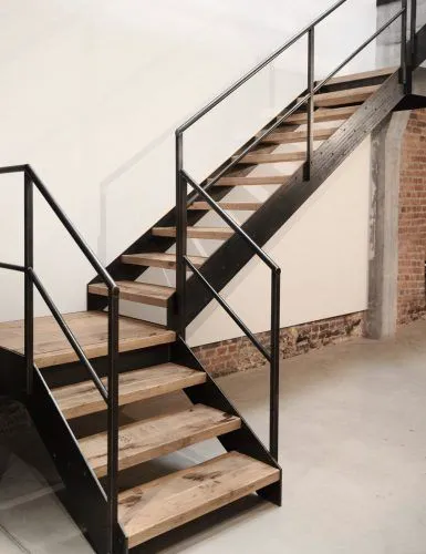 Stahltreppe mit Holzstufen und Metallgeländer in modernem Innenraum