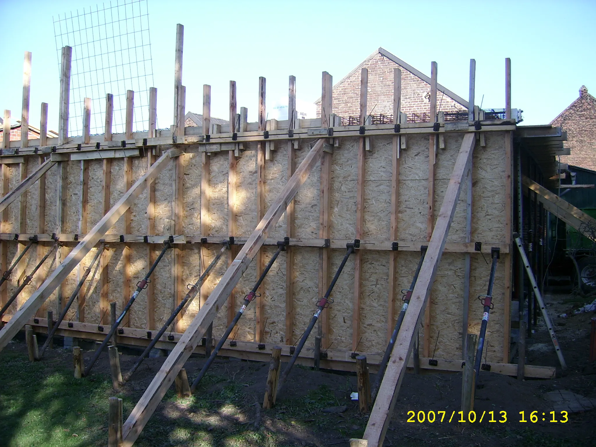 Holzverschalung für Fundament mit Stützstreben und OSB-Platten auf Baustelle im Garten