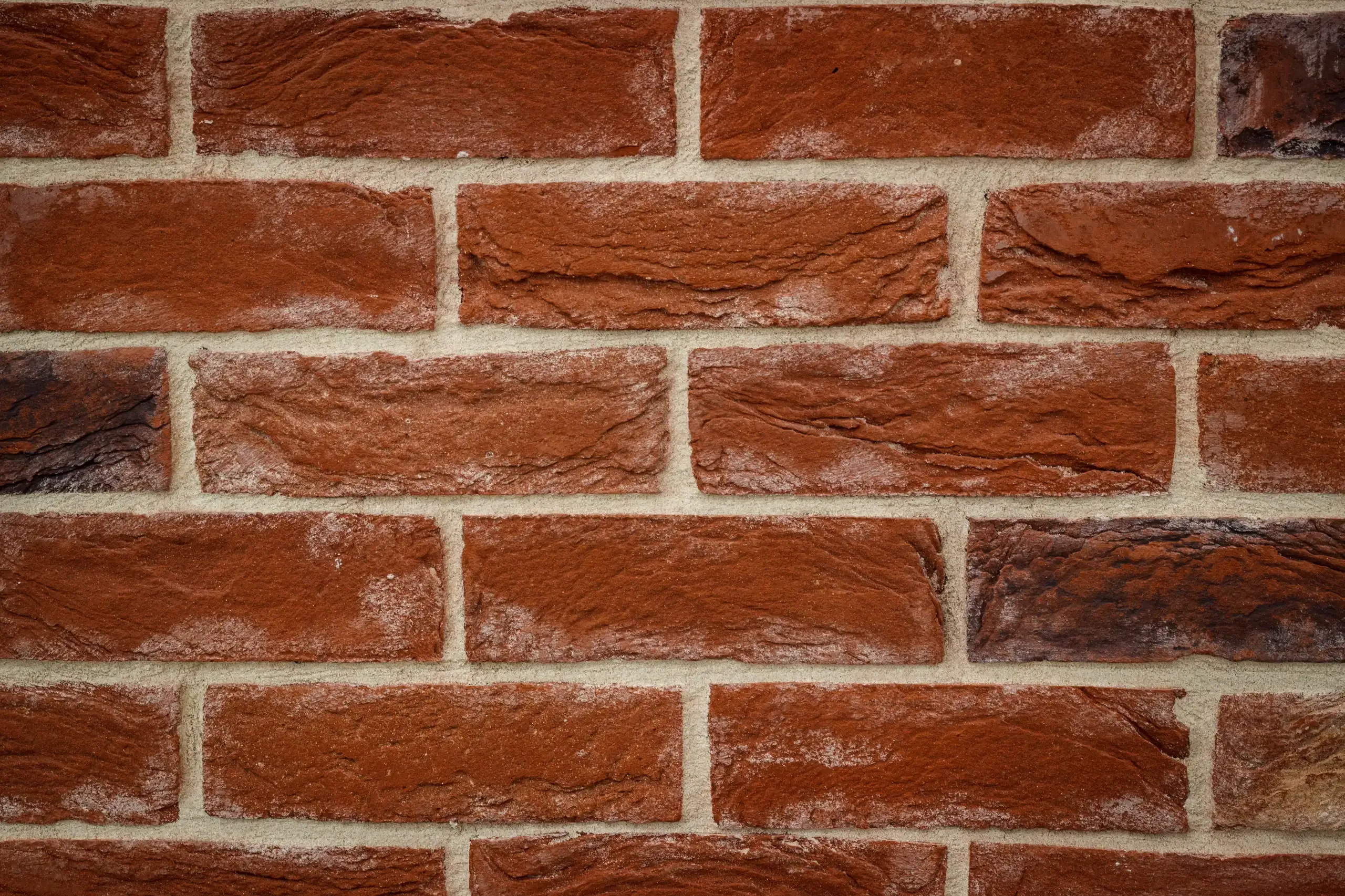 Nahaufnahme einer roten Klinkerwand mit regelmäßigen Fugen als Klinkerriemchen-Fassade